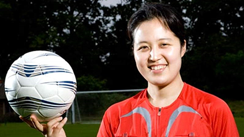 image of una hong holding football in one hand
